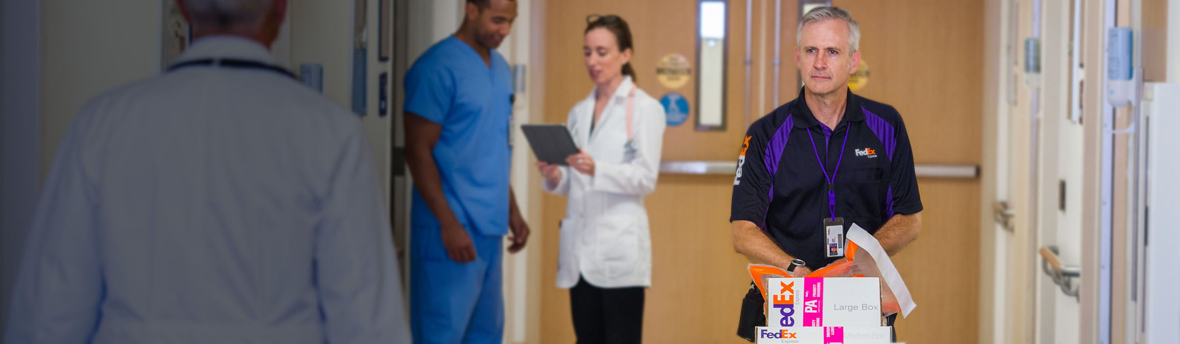 FedEx courier walking down a hall in a hospital