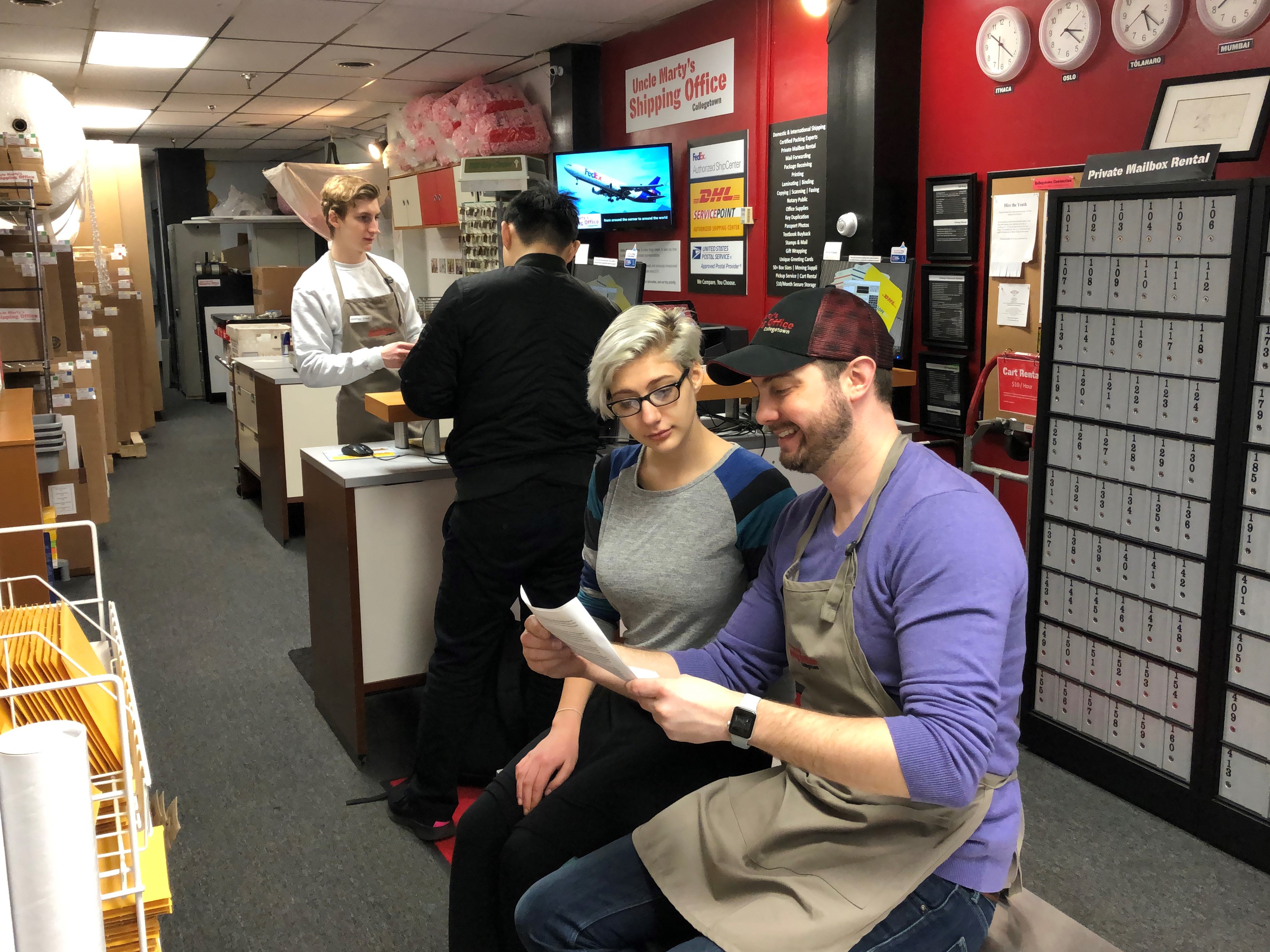 Marty Johnson, owner of Uncle Marty's Shipping Office, talking to a college-student customer. 