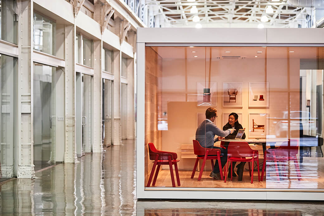 Coworkers collaborating in a glass conference room