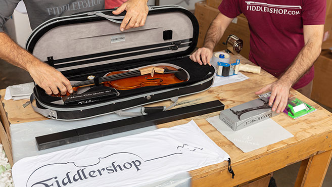 Man placing fiddle in fiddle case