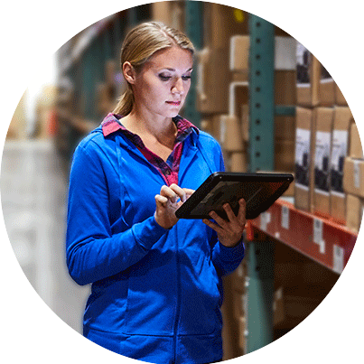 Woman working on a tablet in a warehouse.