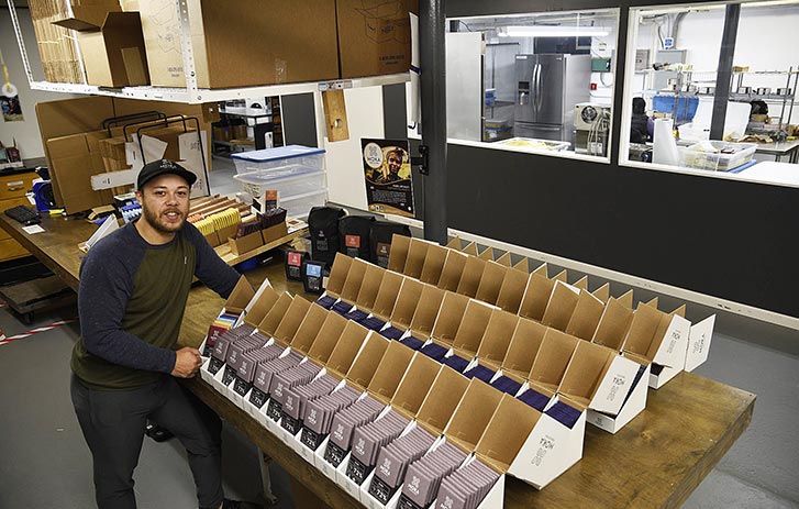 Moka Origins shipping manager standing over orders in warehouse