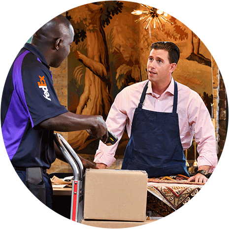 FedEx driver with hand truck of packages talking to a small business owner