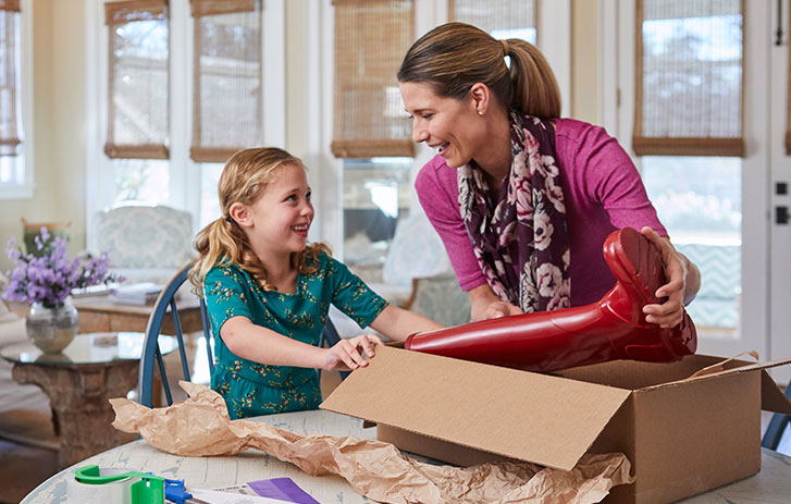 A mother and daughter packing a box for return
