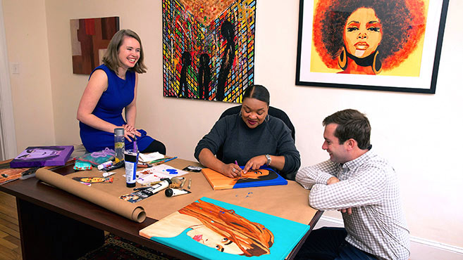 business owners watching artist work on art