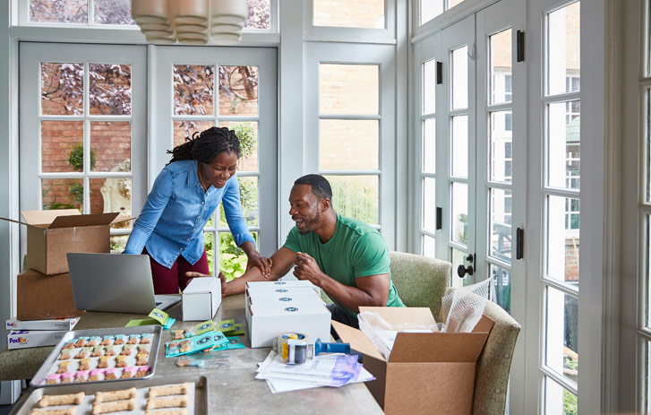 couple in home office packaging goods for shipping