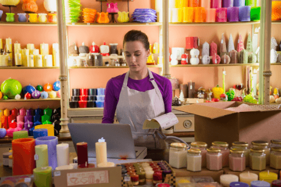 Female business owner packing candles to ship