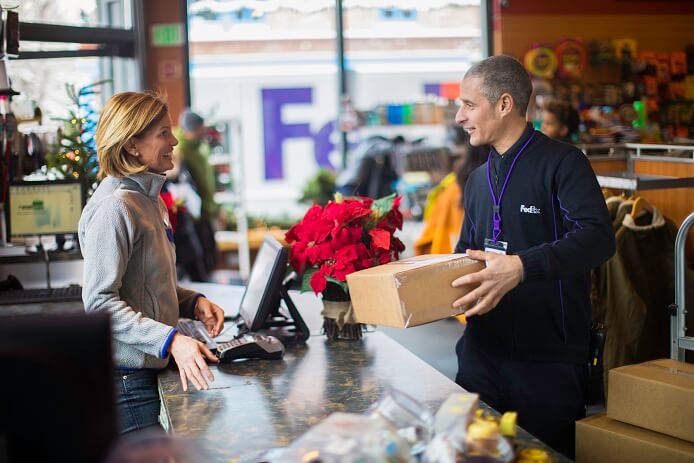 fedex delivery driver picks up packages - peak