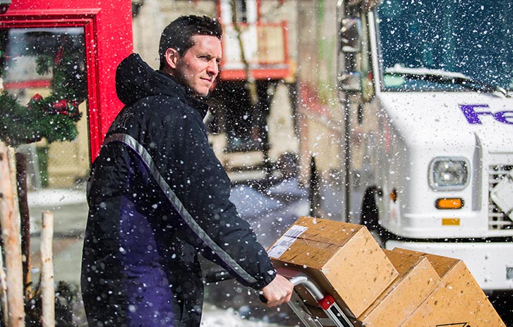 courier with packages in snow