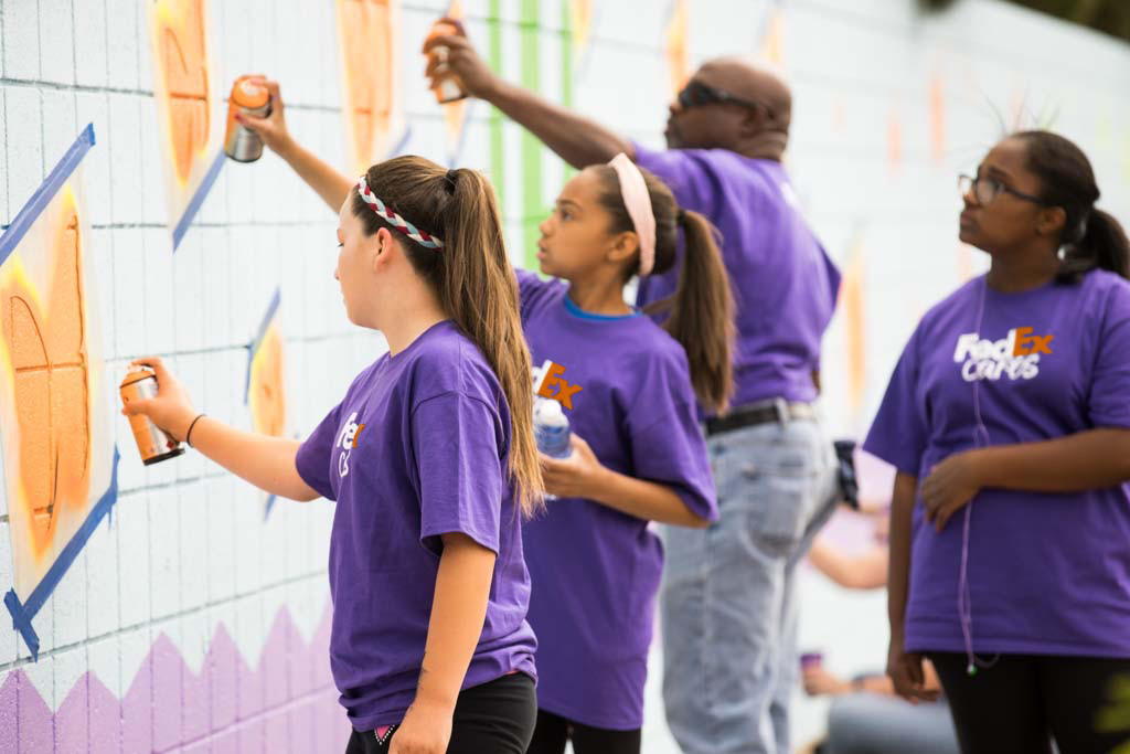 Volunteers painting a wall 