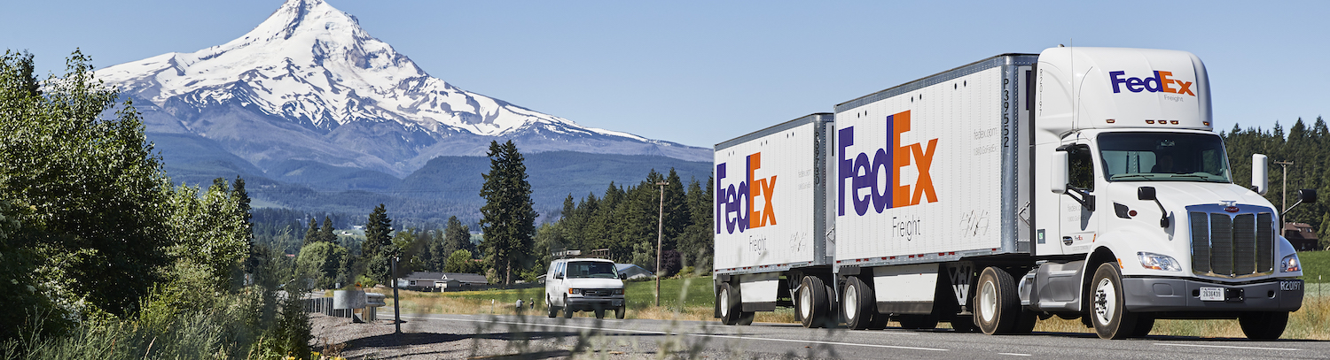 FedEx Freight truck on a road with trees