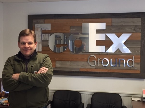 Photo of team member in front of FedEx Ground sign