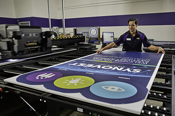 FedEx Office team member printing a banner