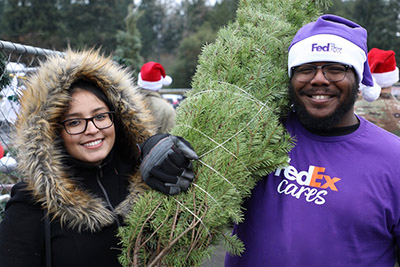 FedEx volunteer with woman and tree