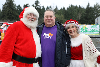 Chuck and Sarah Fiske standing with FedEx Freight CEO John Smith
