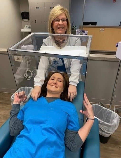 Stephanie Yarbro y una compañera muestran cómo se usa la caja de intubación.