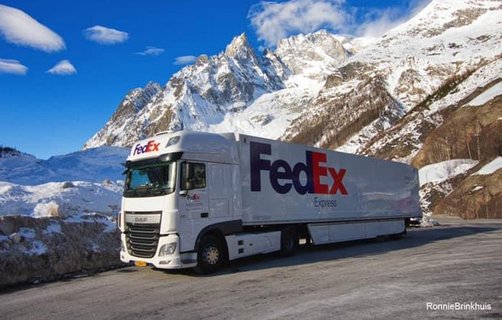 FedEx truck driving past a mountain view