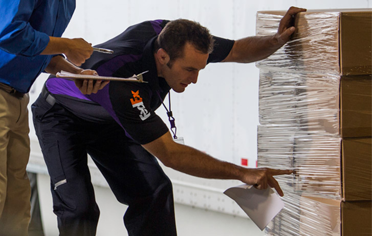 fedex worker safely inspecting freight