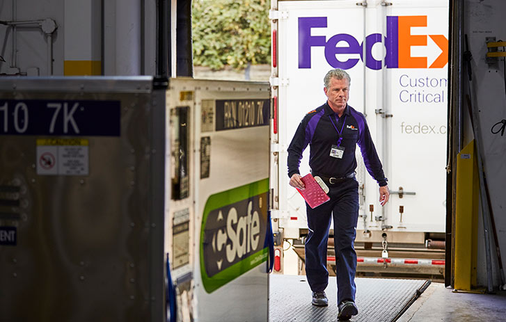 A FedEx driver walking into a warehouse