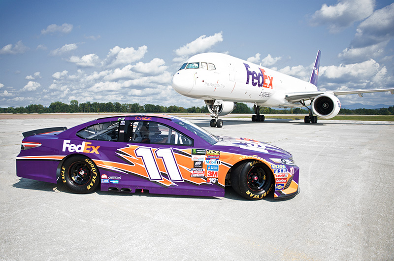#11 FedEx Race car on an tarmac with a FedEx Plane