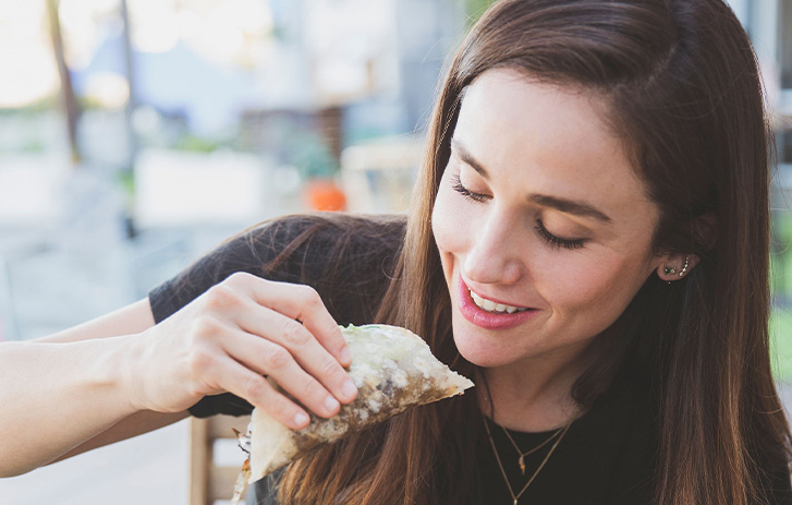 A women eating a taco