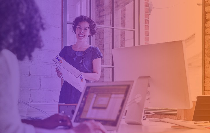 smiling woman holding fedex package in office
