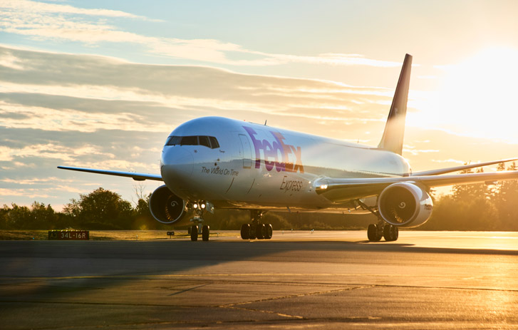 FedEx plane on the ground with a sunrise