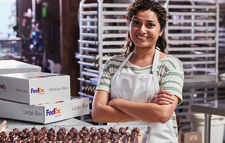 Business woman happy posing with FedEx boxes