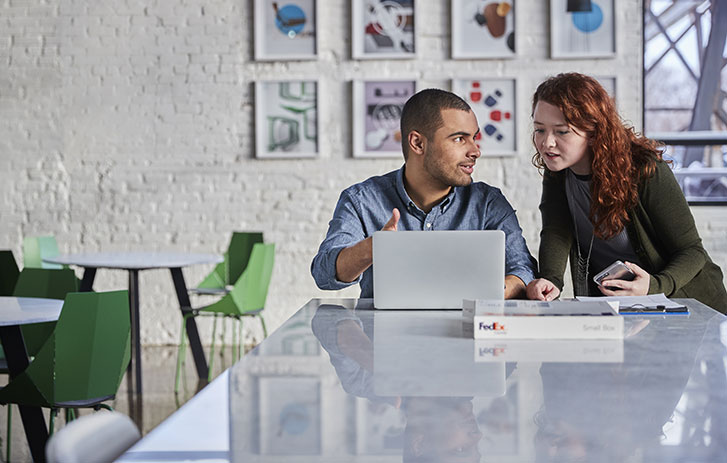 two professionals looking together at a laptop