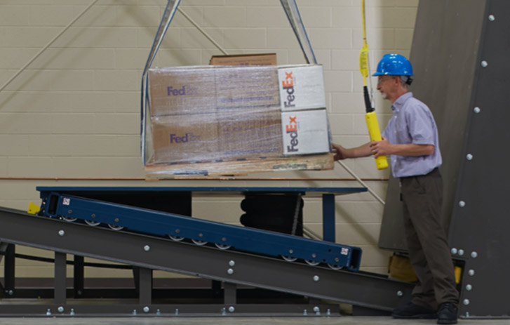 Packaging Lab Engineer testing FedEx boxes on a pallet.