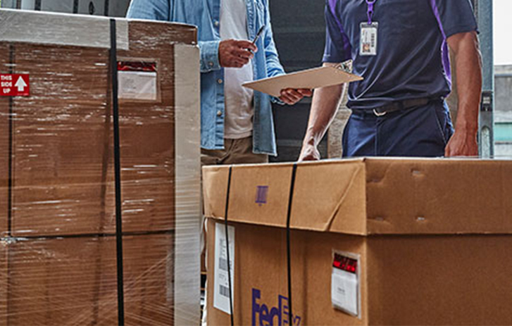 FedEx Freight employee standing in front of boxes.