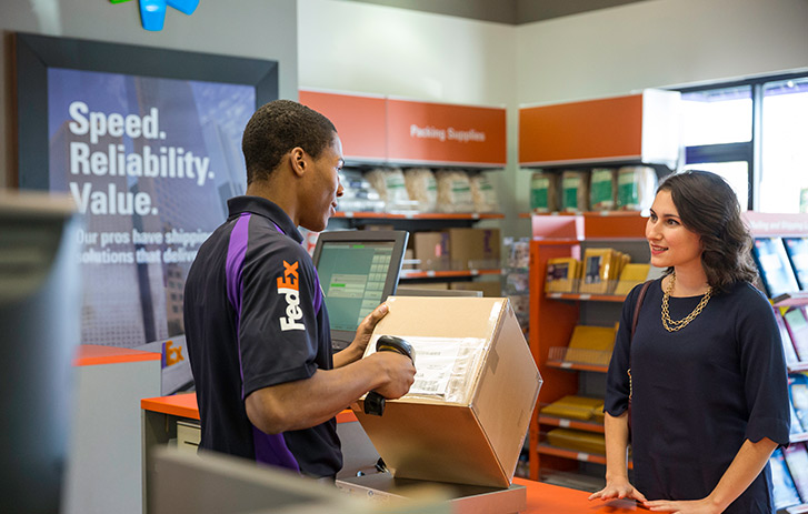 FedEx employee scanning a brown box a customer brought in with the retail packing supplies in the background. Find shipping boxes near you.