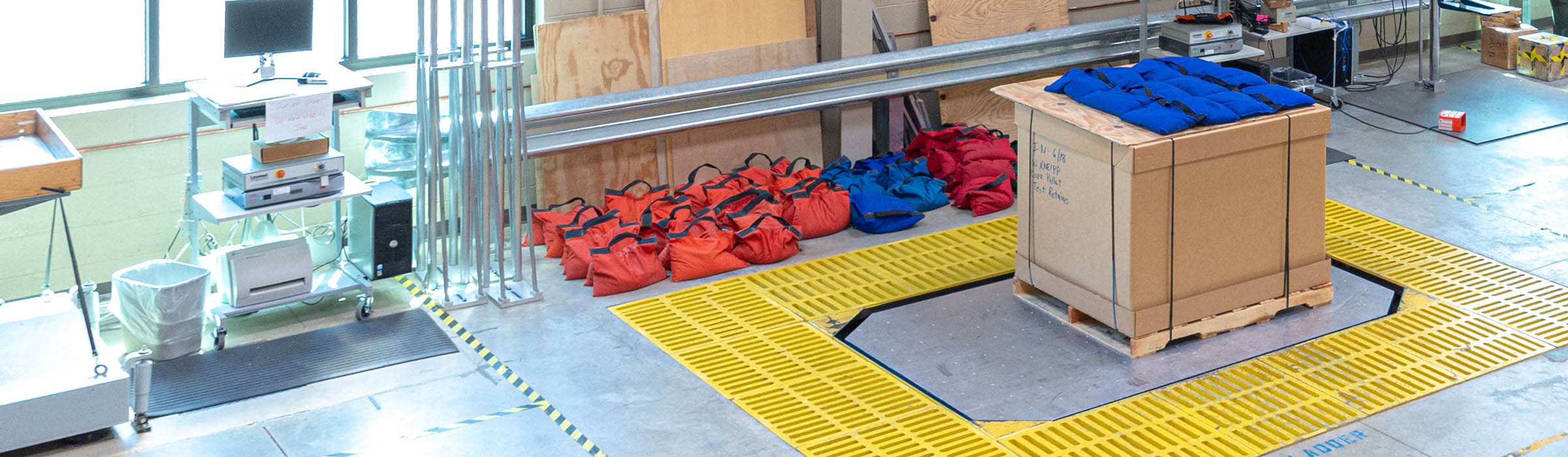 Image of box on floor scale with weights in the FedEx Packaging lab.