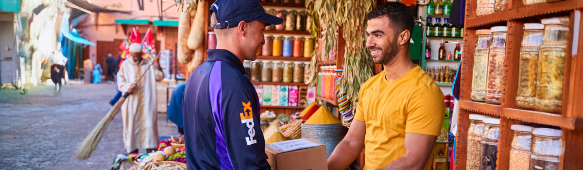 A FedEx delivery person giving a package to a customer.