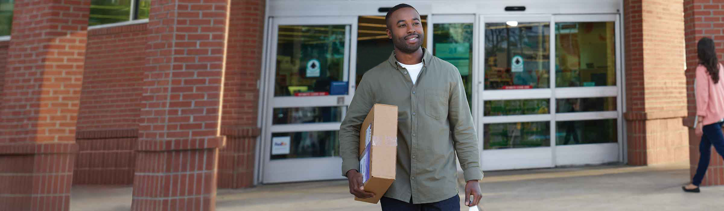 Customer walking out of Walgreens with a package