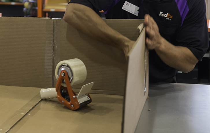 Image of a FedEx employee creating a custom box solution.