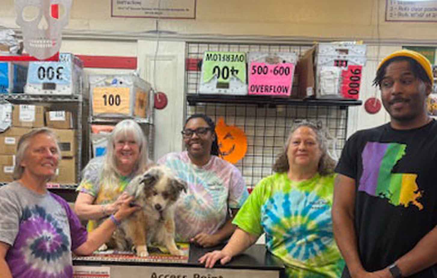 Picture of a store owner with four employees and a dog inside a FedEx Authorized ShipCenter.