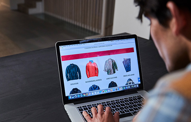Man online shopping for coat on laptop