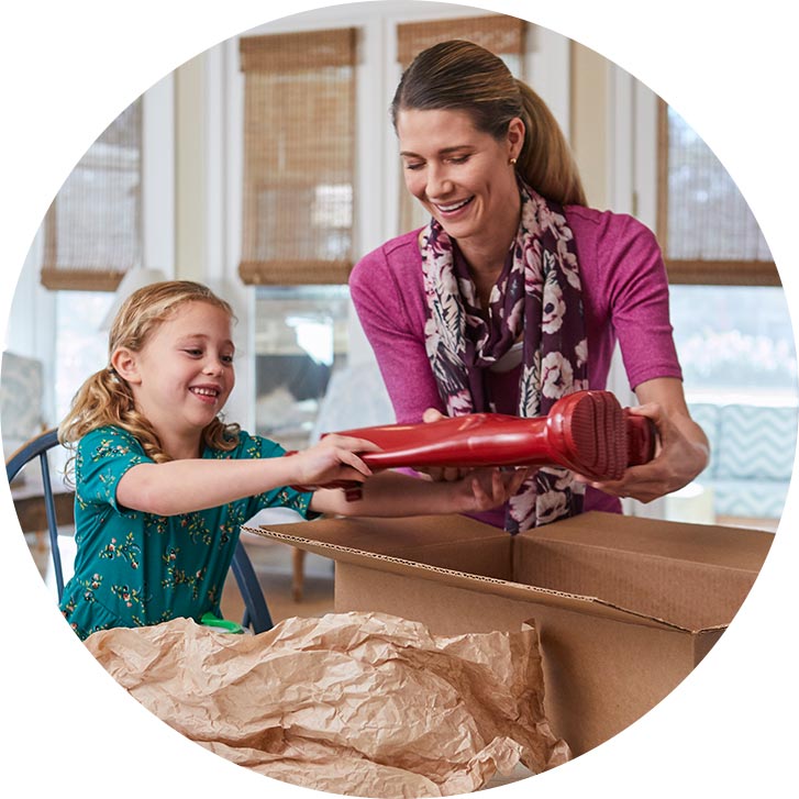 mother and daughter packing box in kitchen