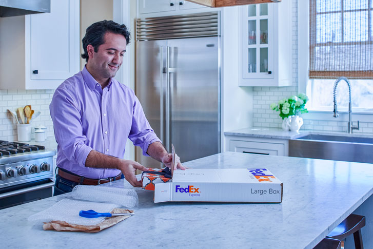 man packing white fedex box himself