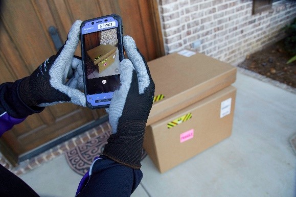 Delivery courier taking photo of package on front steps Delivery courier taking photo of package on front steps