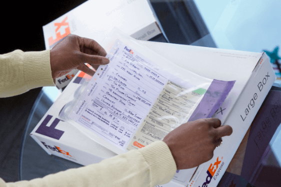 Man applying label to FedEx box