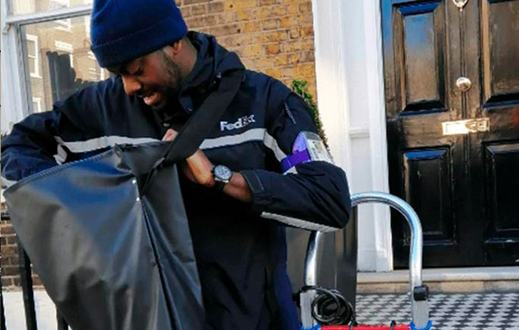 courier da FedEx olhando dentro da bolsa
